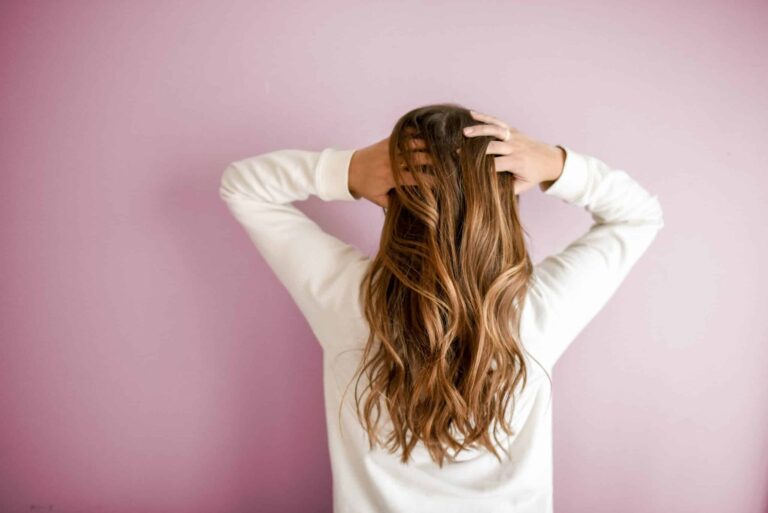 back of woman with hands in her long hair